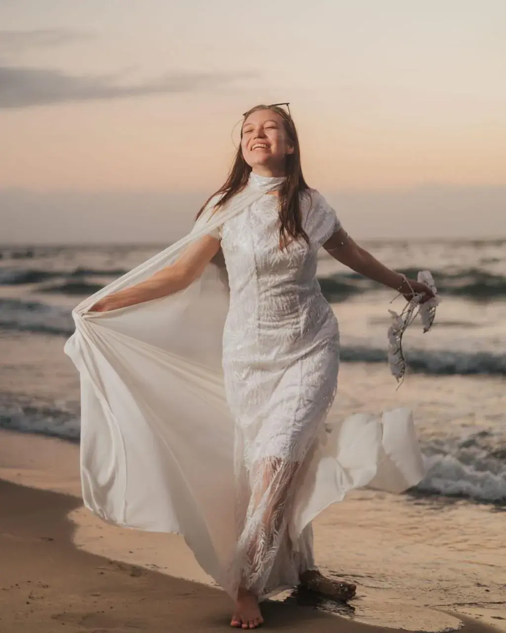 Ángela Giraldo con vestido blanco junto al mar