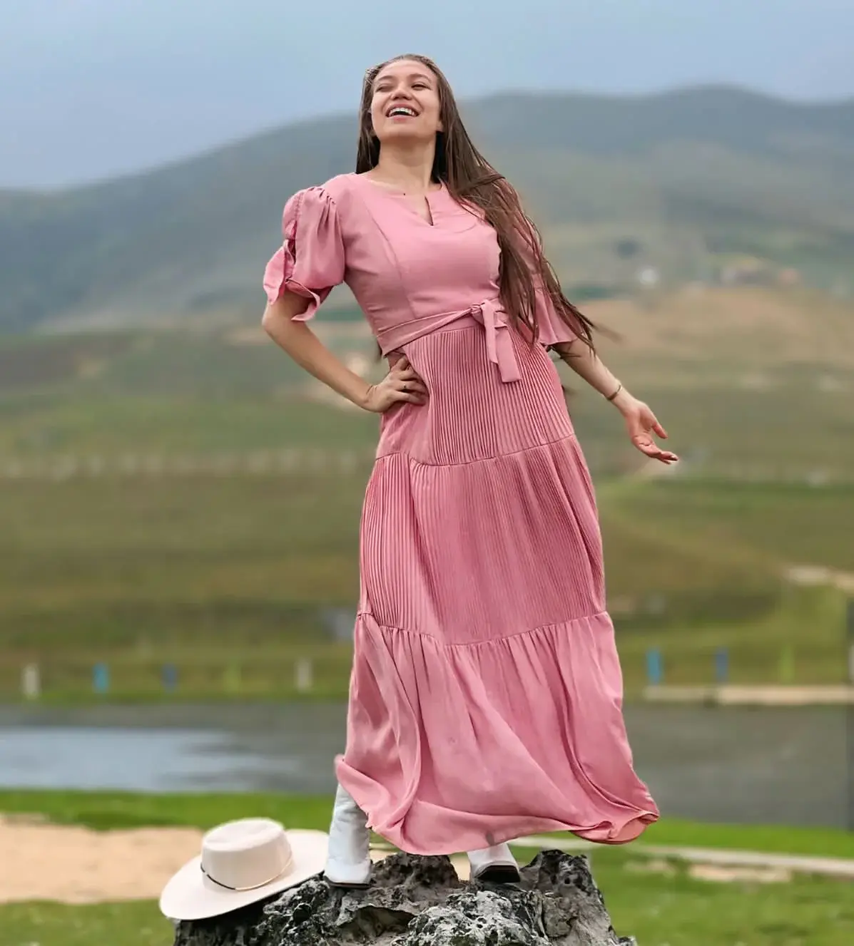 Ángela Giraldo con vestido rosa en un paisaje natural
